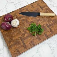 Afbeelding in Gallery-weergave laden, Sfeerbeeld van de Kopshouten snijplank met daarop uien, knoflook, bieslook en een keukenmes.